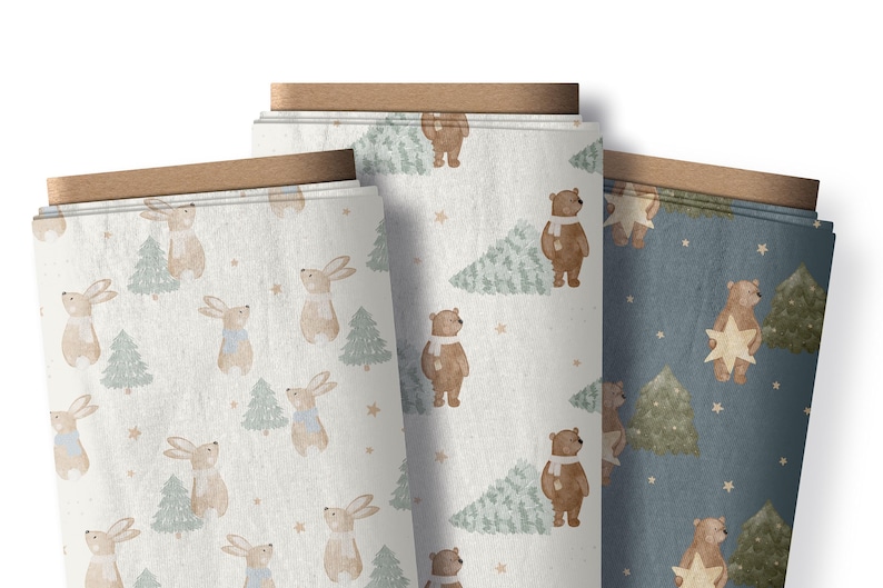 May include: Three rolls of fabric with winter-themed patterns. One roll features rabbits and Christmas trees, another has bears and trees, and the third has bears holding stars. The fabric has a light color palette.