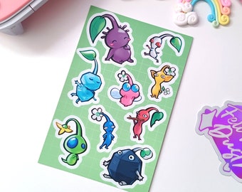 Könnte beinhalten: Ein Set mit neun bunten Aufklebern mit Comicfiguren in verschiedenen Farben und Designs. Die Aufkleber befinden sich auf grünem Hintergrund und eignen sich perfekt, um jedem Projekt einen Hauch von Verspieltheit zu verleihen.