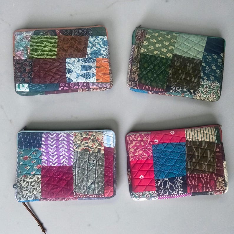 May include: Four rectangular patchwork zipper pouches. Each pouch features a unique combination of patterned fabrics in various colors, including green, blue, red, and purple. The pouches are quilted and have a zipper closure.