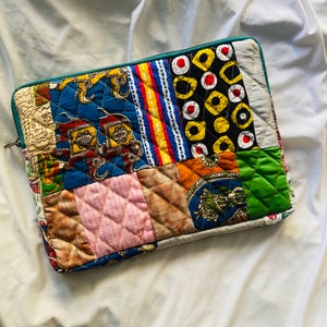 laptop cover, case cover for macbook air, cover for hp laptop, laptop sleeves all sizes, cute laptop sleeves, quilted laptop cover, puffy laptop sleeve, laptop sleeve 13 inch macbook air, laptop sleeve, laptop sleeve custom size, laptop cover 15 inch, An eco-friendly laptop sleeve showcasing a mix of vibrant, multicolor solid patchwork fabric pieces, creating a bold and eye-catching design. The quilted, puffy construction ensures your laptop is well-protected