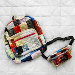 May include: A patchwork quilt backpack and a matching bum bag. Both bags are made of colourful fabric scraps sewn together in a patchwork design. The backpack has a large main compartment and a smaller front pocket. The bum bag has a zippered closure.