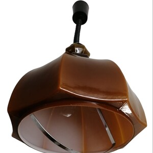 May include: A brown ceramic pendant light fixture with a white inner shade and a black cord.