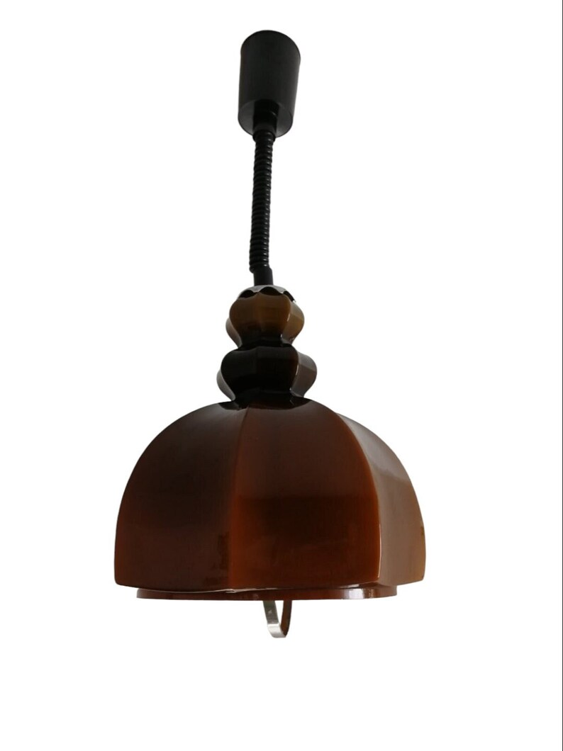 May include: A brown ceramic pendant light with a black flexible cord and a brown and black ceramic base.