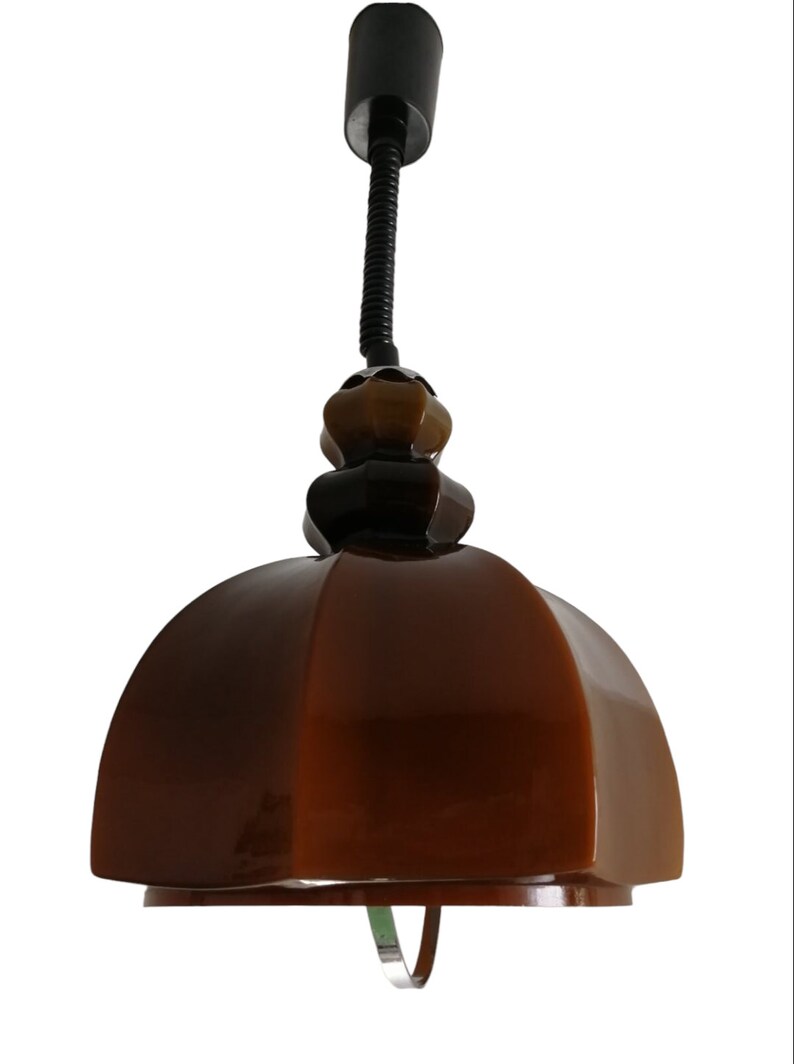 May include: A brown ceramic pendant light with a black adjustable cord and a brown and gold ceramic finial.