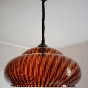May include: A brown and black striped pendant light fixture with a black cord.