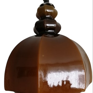May include: A brown ceramic pendant light with a dome-shaped shade and a three-tiered, bulbous top.