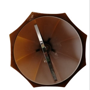 May include: A brown umbrella-shaped lampshade with a metal frame and a white interior. The lampshade is designed to be used with a standard light bulb.