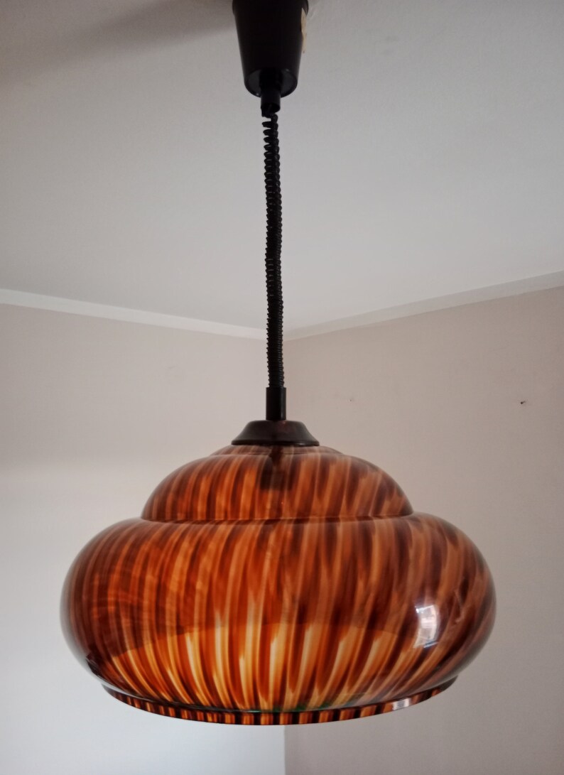 May include: A brown and white striped pendant light with a black cord.