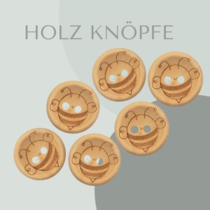 Może przedstawiać: Sześć drewnianych guzików z motywem pszczoły. Pszczoły są brązowe i żółte z białymi oczami. Wszystkie guziki są tego samego rozmiaru i kształtu.