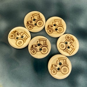 Pode incluir: Seis botões de madeira com um design de trator. Os botões são de cor castanho claro e têm um acabamento em madeira natural.
