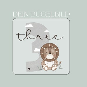 Könnte beinhalten: Ein grau-weißer Bügelbild mit dem Wort "three" in Kursivschrift und einem Cartoon-Löwen, der eine braune Mähne trägt. Der Löwe sitzt auf einem grauen Hintergrund mit weißen Wolken.