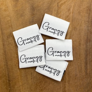 May include: Five white fabric labels with black text that reads "Granny made it".