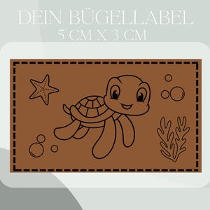 Könnte beinhalten: Eine Schwarz-Weiß-Zeichnung einer Schildkröte auf braunem Hintergrund. Die Schildkröte schwimmt mit ausgestreckten Flossen. Im Hintergrund befinden sich Blasen und ein Seestern. Der Text "DEIN BUGELLABEL 5 CM X 3 CM" befindet sich oben im Bild.