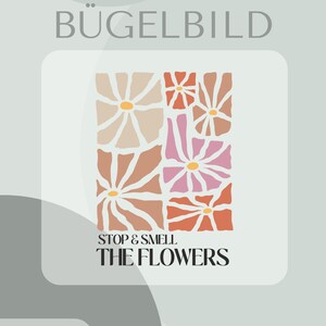 Könnte beinhalten: Ein quadratisches Blumendesign mit dem Text "STOP & SMELL THE FLOWERS". Das Design zeigt Blumen in Pfirsich-, Rosa- und Orangetönen mit gelben Zentren. Die Wörter "BÜGELBILD" und "Inklusive Anleitung und Test-Bügelbild" sind ebenfalls sichtbar.