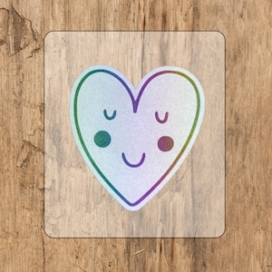 May include: A sticker of a heart with a smiling face. The heart is outlined in rainbow colours and has a white background.