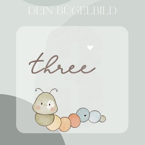 Könnte beinhalten: Ein hellblaues und weißes Bügelbild mit einer Cartoon-Raupe und dem Wort "three" darüber. Die Raupe besteht aus Kreisen in verschiedenen Brauntönen, Orange und Blau.