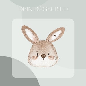 Op de afbeelding: Een bruin konijn met een klein hartje op zijn oor. Het konijn kijkt naar voren met zijn oren omhoog. De achtergrond is lichtblauw.