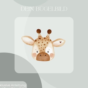Op de afbeelding: Waterverfillustratie van een giraffekop met bruine vlekken, oren en een hartdetail. De tekst "DEIN BÜGELBILD" staat bovenaan en "Inklusive Anleitung und Test-Bügelbild" onderaan. De giraffe heeft een lieve uitdrukking.