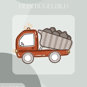 May include: A cartoon illustration of a red dump truck carrying gray rocks. The truck has white wheels and a white window. The image includes the text "DEIN BÜGELBILD" and "Inklusive Anleitung und Test-Bügelbild".