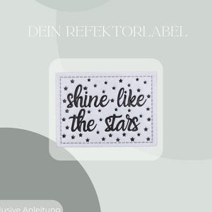 Könnte beinhalten: Ein weißes rechteckiges Patch mit schwarzem Nahtrand und dem Schriftzug "shine like the stars" in schwarzer Schrift. Kleine schwarze Sterne sind über dem Patch verstreut. Der Hintergrund ist hellgrün.