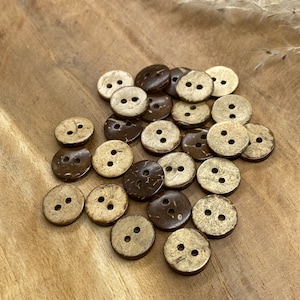 May include: A pile of brown and beige coconut shell buttons with two holes each.