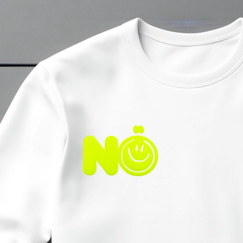 Może przedstawiać: Biała bluza z neonowo-zieloną grafiką z napisem "N&ouml;" i emotikonem uśmiechu. Bluza ma okrągły dekolt i długie rękawy. Grafika jest wyśrodkowana na klatce piersiowej.
