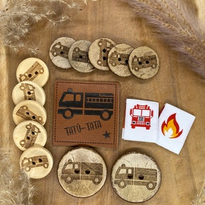 May include: A set of wooden buttons with a fire truck design, a leather patch with the text "TATU-TATA" and a star, and two fabric patches with a fire truck and a flame design.