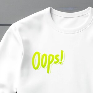 May include: White sweatshirt with a neon green "Oops!" graphic printed on the front.