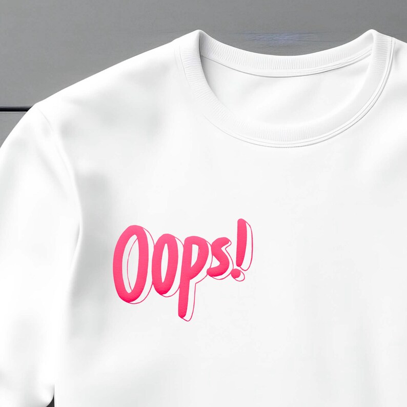 May include: White long-sleeve shirt with a pink "Oops!" graphic printed on the front.