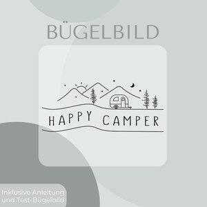 May include: A black line art iron-on transfer featuring a camping scene with mountains, a sun, a crescent moon, stars, pine trees, and a small camper trailer. The text HAPPY CAMPER is printed in a simple sans-serif font below the illustration.