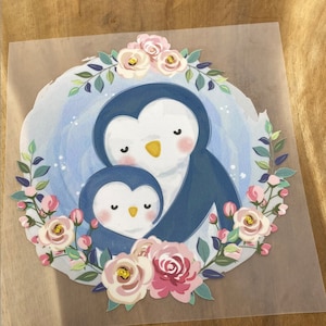 Peut inclure: Un couple de pingouins bleus et blancs entourés de fleurs roses et vertes. Les pingouins se tiennent l'un l'autre et ont un motif en forme de cœur sur la poitrine.