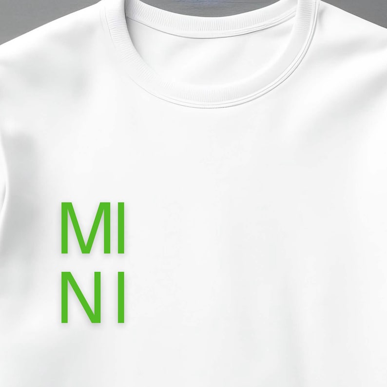 Puede incluir: Sudadera blanca de cuello redondo con la palabra "MINI" impresa verticalmente en letras de bloque verde brillante. La sudadera tiene un estilo cl&aacute;sico e informal.