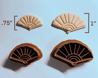 May include: Two sets of fan-shaped cookie cutters. One set is brown plastic and the other is beige plastic. The cutters are 0.75 inches and 1 inch wide.