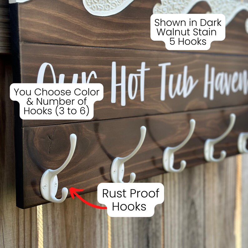 K&ouml;nnte beinhalten: Ein Wandgarderobe aus Holz mit wei&szlig;en Haken. Das dunkelbraune Holz ist mit einer Walnuss-Oberfl&auml;che gebeizt. Der Text "Our Hot Tub Haven" ist in Wei&szlig; dargestellt. Die Garderobe hat rostfreie Haken, und die Farbe und Anzahl der Haken k&ouml;nnen angepasst werden.