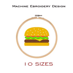 May include: Machine embroidery design of a yellow hamburger with sesame seeds, lettuce, tomato, and cheese. The design is displayed in a wooden embroidery hoop. The text "10 SIZES" is displayed below the hoop.