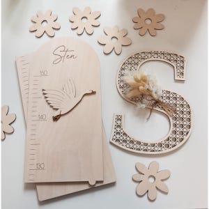 K&ouml;nnte beinhalten: Holz-Kinderzimmer-Dekor-Set mit einer Wachstumstabelle mit einer Gans, dem Namen "Sten" und einem dekorativen Buchstaben "S" mit gewebtem Design. Enth&auml;lt Holzblumen-Ausschnitte. Die Wachstumstabelle misst bis zu 150 cm.