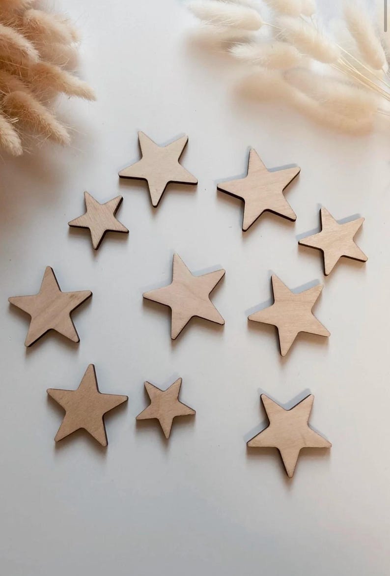May include: A set of ten wooden stars in various sizes, all with a natural wood finish. The stars are arranged in a circle on a white background.