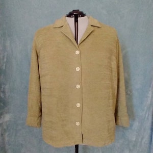 Puede incluir: Una camisa de manga larga de color marrón claro con botones y cuello.