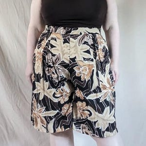 May include: Black and beige floral print shorts with a high waist and a relaxed fit.