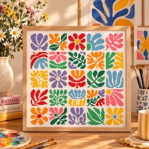 May include: A square framed cross-stitch embroidery featuring a grid of twenty-five colorful floral and botanical motifs. Each square displays a unique plant or flower design in vibrant shades of red, orange, yellow, green, blue, and purple.