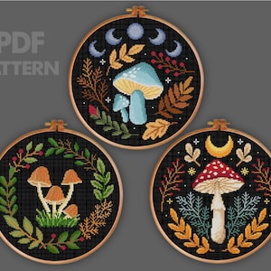 May include: Three cross-stitch patterns in wooden hoops. The designs feature mushrooms, leaves, and moons on a black background. The text "PDF PATTERN" is visible in the upper left corner. The color palette includes shades of blue, brown, red, and green.