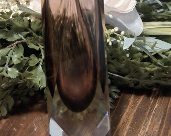 May include: A tall, rectangular vase with a faceted base and a square opening. The glass has a gradient of brown and clear tones. The vase is likely used for floral arrangements or decorative purposes.
