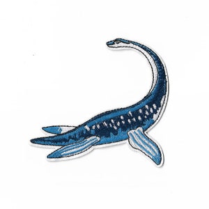 Peut inclure: Un écusson brodé représentant une créature aquatique à long cou, probablement un plésiosaure, dans des tons bleu foncé et bleu clair avec des accents blancs. Le motif montre la créature avec un cou courbé, des nageoires et un corps texturé.
