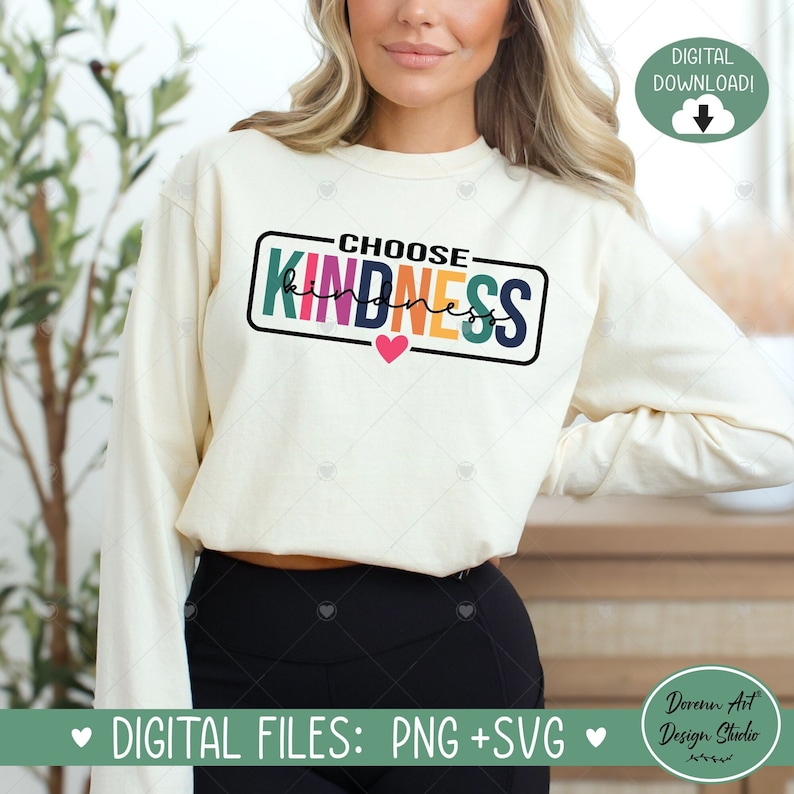 Op de afbeelding: Een wit sweatshirt met de tekst "CHOOSE KINDNESS" in een kleurrijk regenboogontwerp in een zwart rechthoek. Een klein roze hart bevindt zich onder de rechthoek. De tekst "DIGITAL FILES: PNG + SVG" staat onderaan de afbeelding.