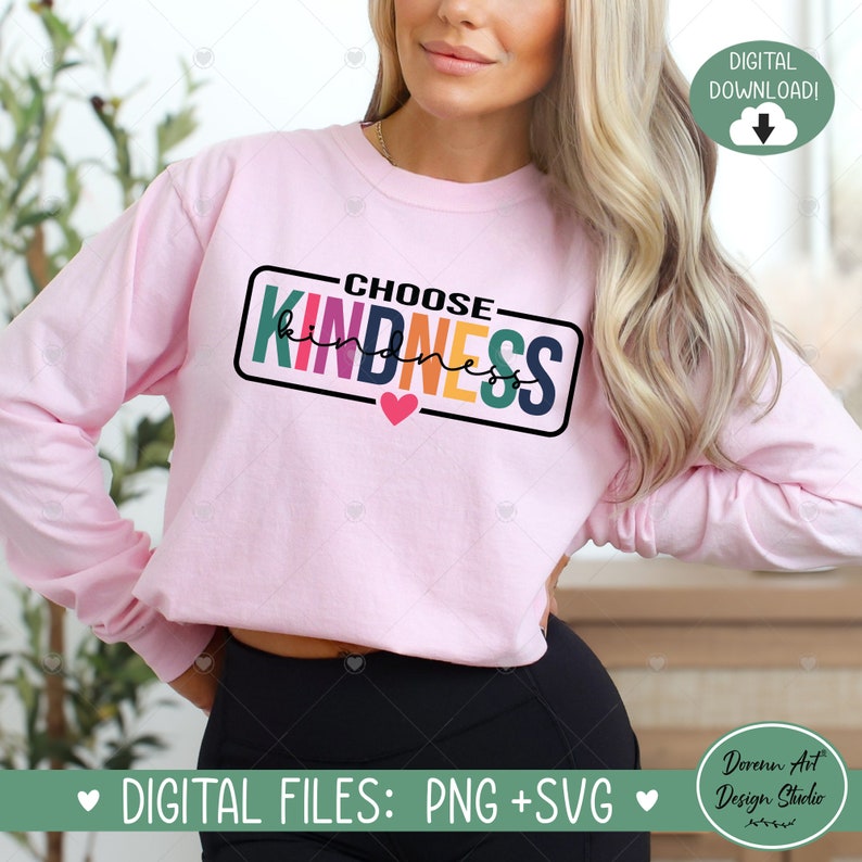 Op de afbeelding: Een roze longsleeve met de tekst "CHOOSE KINDNESS" in een kleurrijk regenboogontwerp. De tekst staat in een zwarte rechthoek met een klein rood hartje eronder.