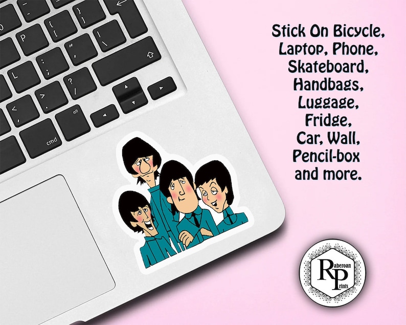 May include: A sticker featuring a cartoon illustration of four people with black hair and blue shirts. The sticker is on a silver laptop with a black keyboard. The text "Stick On Bicycle, Laptop, Phone, Skateboard, Handbags, Luggage, Fridge, Car, Wall, Pencil-box and more." is written in black text on a pink background. The text "aberoan Rp rinh" is written in black text on a white circle with a black border.