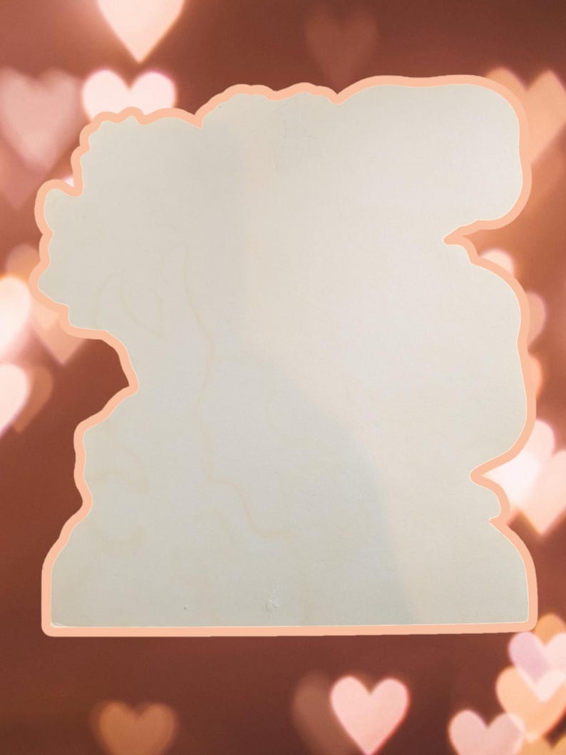 May include: Blank wooden cutout in the shape of a woman's head with a floral design around the edges. The cutout is a light beige color and has a smooth surface.