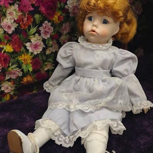 Vintage porcelain doll with red hair and lilac dress