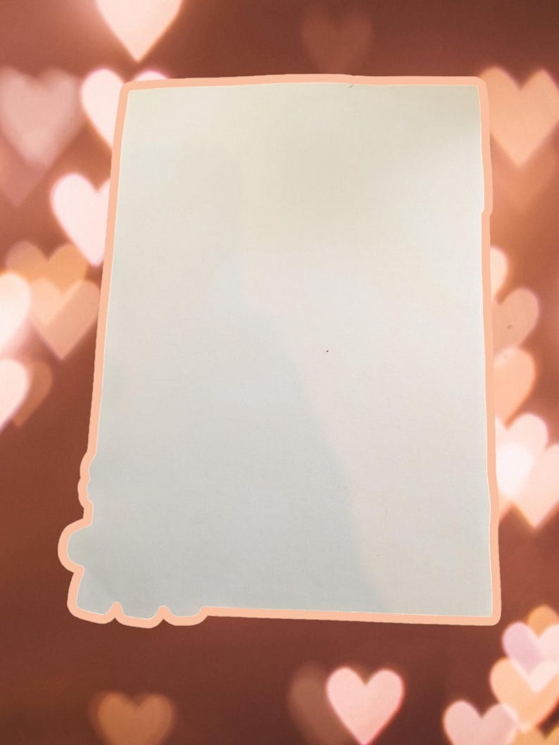 May include: A blank white card with a light peach border. The card is against a background of out-of-focus pink hearts.