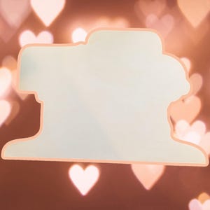 May include: A white silhouette of a person's head and shoulders with a blurred background of out-of-focus hearts in shades of pink and orange.